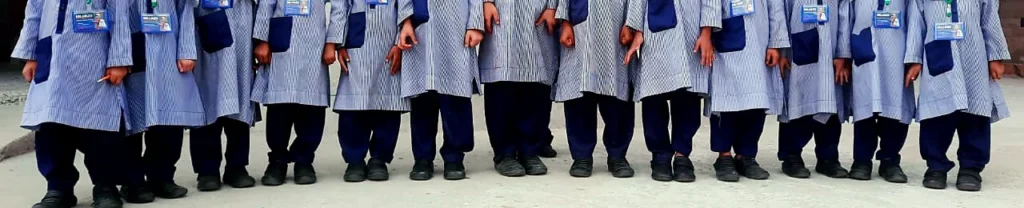 A row of pupils’ uniforms, lanyards and school shoes.