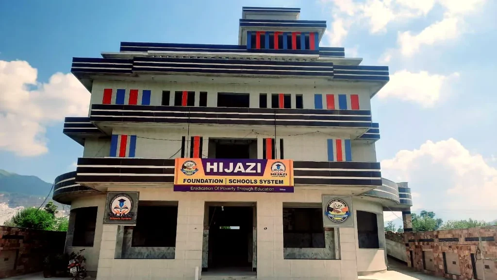 The three-storey Hijazi school building in Buner under a blue sky, its sign reading Hijazi Foundation Schools System.
