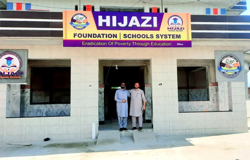 The school entrance under the sign: Hijazi Foundation, Schools System, Eradication of Poverty Through Education.